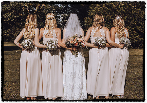 Bridesmaid boho holding bouquet at the back